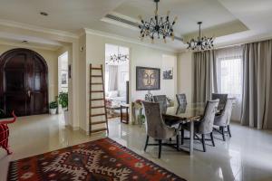 - une salle à manger et un salon avec une table et des chaises dans l'établissement Spacious,amazing villa with a beautiful blooming garden!, à Dubaï