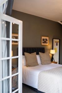 um quarto com uma cama branca e uma parede verde em The Plough Itchen Abbas em Winchester