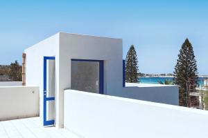 a white house with a blue door and a fence at Lisca Bianca in San Vito lo Capo