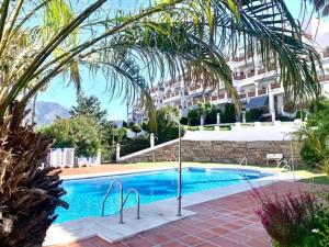 a swimming pool in front of a building at Sunset apartment, front line Mijas Golf in Mijas