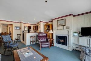 a living room with a fireplace and a tv at 212 Water Street Inn in Boyne City