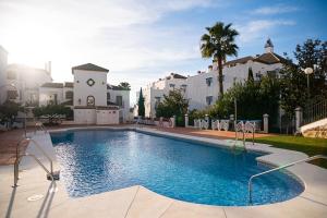 a large swimming pool in front of a building at Sunset apartment, front line Mijas Golf in Mijas