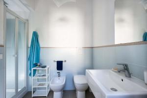 a white bathroom with a sink and a toilet at Lisca Bianca in San Vito lo Capo