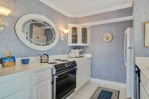 a kitchen with white cabinets and a stove and a mirror at 215 Water Street Inn in Boyne City