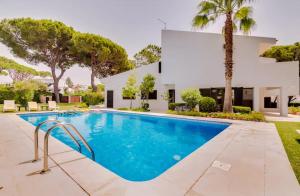 a swimming pool in front of a house at Vila Alice in Quarteira