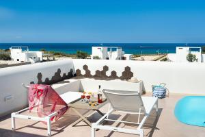 een tafel en stoelen op een balkon met uitzicht op de oceaan bij San Lorenzo - Palma in Siracusa