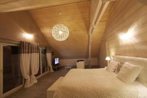 - une chambre avec un grand lit et une télévision dans l'établissement Chambres d'hôtes Couleurs Bois & Spa, à Xonrupt-Longemer