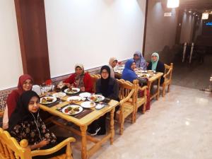 a group of people sitting at tables eating food at 2nd floor in Bukhara