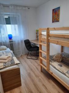 a room with two bunk beds and a desk at Moderne 3Zimmer Wohnung, in Königsbrunn bei Augsburg in Königsbrunn