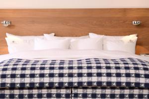 a bed with a blue and white comforter at chez Douverne Hotel mit Hästens Betten in Sommerach