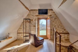 a living room with a chair and a window at MAS DEL LUM in Boussac