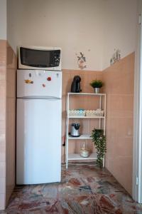 a kitchen with a microwave on top of a refrigerator at Afrodite Loft Hermes in Verona +16 photos