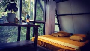 1 dormitorio con cama, mesa y ventana en Riverston Nature Villa, en Rattota