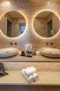 two sinks in a bathroom with two mirrors at ISAVORIA ECO CHIC RESORT in Parga