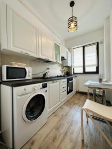 a kitchen with a washing machine and a table at Luxury Studios in Iaşi