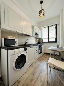 una cucina con lavatrice e forno a microonde di Luxury Studios a Iaşi