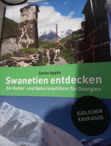 a book with a picture of a mountain at Ushguli Hotel Riho in Ushguli