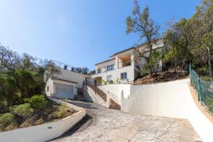 a house on a hill with a driveway at Villa Kristi 9 pers privat pool in Calonge