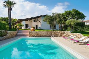 una piscina con sillas y una casa en Blue Moon, en Fontane Bianche