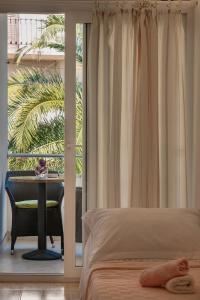 a bedroom with a bed and a table and a balcony at House Marta in Baška Voda