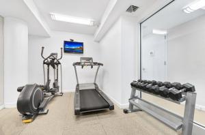 - une salle de sport avec 2 tapis de course et un miroir dans l'établissement Amazing Midtown W 1BR w Gym nr Times Sq NYC-650, à New York