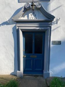a blue door with a clock on top of it at Stunning 4-bed Grade II house in the Lake District in Wigton