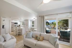 a living room with a white couch and a kitchen at Hidden Pearl home in Holmes Beach