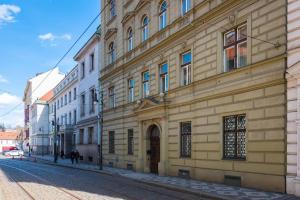 a large building on a street with people walking past it at Vals Garden Apartment in Prague