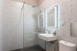 a bathroom with a sink and a glass shower at Vals Garden Apartment in Prague