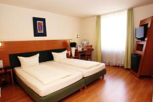 1 dormitorio con 1 cama grande y 1 mesa en Memphis Hotel, en Frankfurt