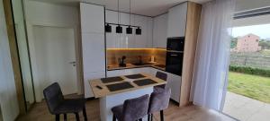 a kitchen with a table and chairs and a sink at Apartman Gaby in Podstrana