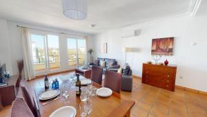 een eetkamer met een tafel en stoelen en een bank bij Penthouse TownCentre-Murcia Holiday Rentals in Roldán