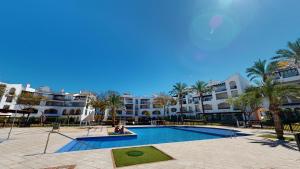 een groot zwembad met palmbomen en gebouwen bij Penthouse TownCentre-Murcia Holiday Rentals in Roldán