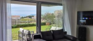 a living room with a couch and a large window at Apartman Gaby in Podstrana