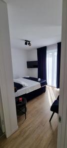 a bedroom with a bed and a chair in a room at Apartman Gaby in Podstrana