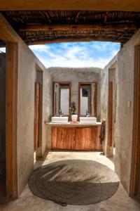 uma casa de banho com 2 lavatórios e um tapete grande em Dar Mar Hostel & Coworking em Paje