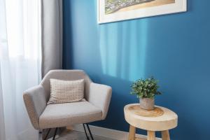 einen Stuhl und einen Tisch in einem Zimmer mit blauer Wand in der Unterkunft Yggotel Solsort in Essen