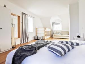 a white bedroom with a large bed with striped pillows at Haus am Deich 47 stilvolles Landhaus an der Elbe in Stadtnähe in Hamburg