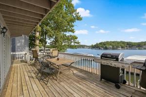 a deck with a grill and a picnic table and a barbecue at Risque Fun One in Lake Ozark