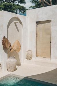 two large vases sitting next to a building with a door at CASA NARA BALI in Munggu