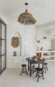 a dining room with a table and chairs and a chandelier at CASA NARA BALI in Munggu