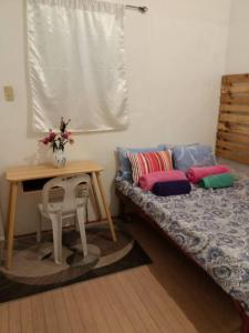 a room with a bed and a table with a bench at Maraño's Home in Legazpi