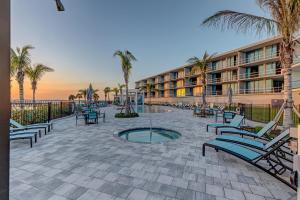 eine Terrasse mit Stühlen und Palmen vor dem Hotel in der Unterkunft Harbor Island Villa Unit 205 in Melbourne Beach