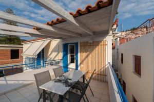 patio con mesa y sillas en el balcón en Luxury Apartment En Lefko, en Poros