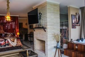 プライア・グランデにあるPousada Green Canyonsのリビングルーム(暖炉、薄型テレビ付)