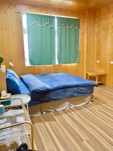łóżko w pokoju z oknem w obiekcie Temu 鐵木蘭農場 w mieście Gauyi