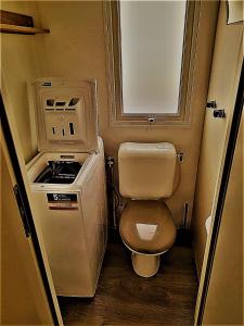 a small bathroom with a toilet and a stove at MOBIL HOME Tendance Tout Confort - FUNPASS non included in Gastes