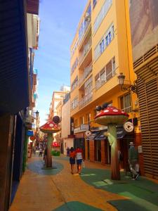 una strada con persone che camminano per strada con ombrelloni di San Francisco ad Alicante