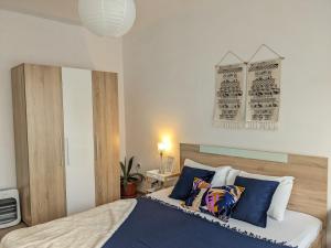 um quarto com uma cama com almofadas azuis e brancas em Welcome Stara Zagora Apartment 4 Guests Pet Friendly em Stara Zagora