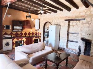 un soggiorno con divano e tavolo di Casas Rurales Las Viñas a Osuna